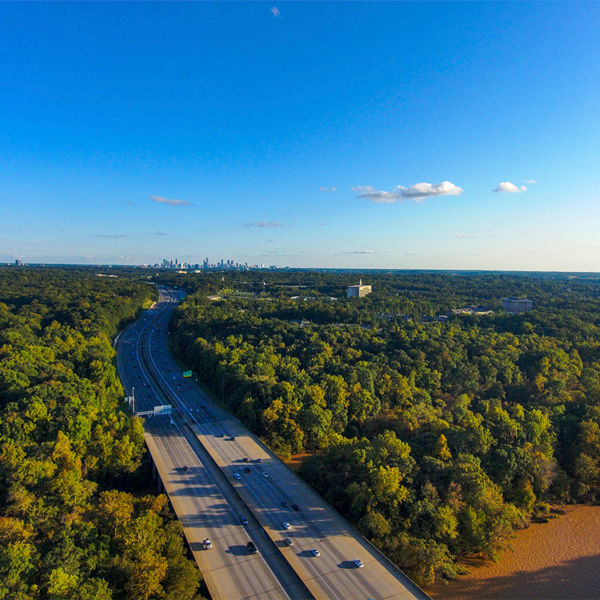 A aerial shot of vast miles of lush green trees, the freeway, the Chattahoochee river and blue sky at sunset at the Chattahoochee River National Recreation Area in Sandy Springs Georgia