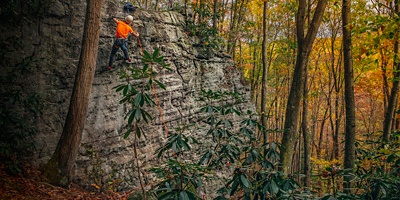 A man climbs up a rock in Ohiopyle