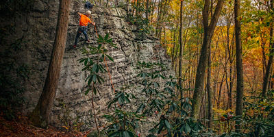 A man climbs up a rock in Ohiopyle