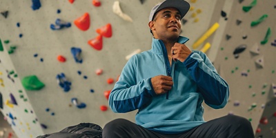 Climber sitting in front of an indoor rock wall