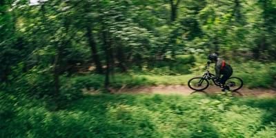 Mountain biker on a narrow path in the woods