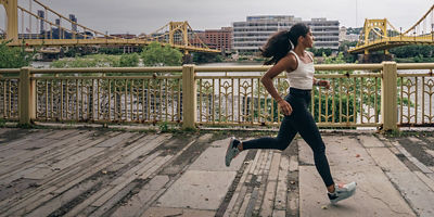 woman running with cityscape behind her