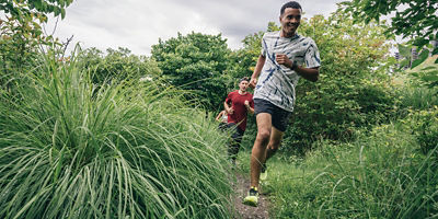 Three runners running on a trail 