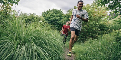 Three runners running on a trail 