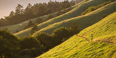 a man running through a hill trail