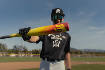 Child baseball player focused ready to bat. Kid holding a baseball