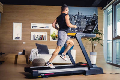 Man running on treadmill in modern living room
