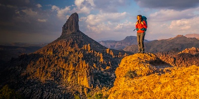 A female backpacker over looking Weavers Needle in the Superstition Wilderness near Phoenix, Arizona.
