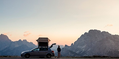 Tre Cime di Lavaredo ("Drei Zinnen"), Sexten Dolomites, Italy: A woman at her car with a rooftop tent at the Rifugio Auronzo.