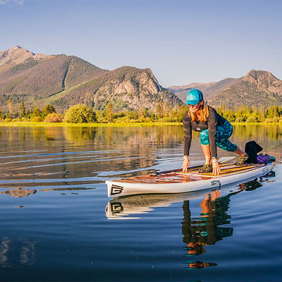 A female paddlboarder on Lake Dillon in Summit County, Colorado in the early morning.
