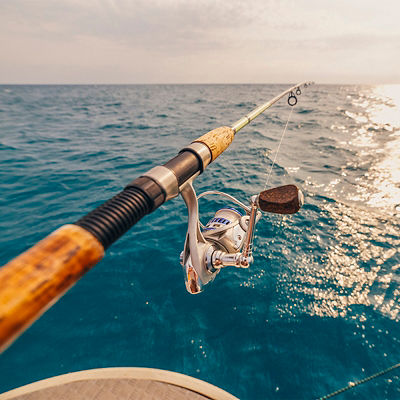 A closeup on an ocean fishing rod off a boat