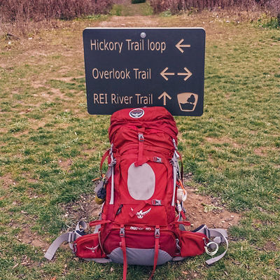 A backpacking bag sits next to a trail sign