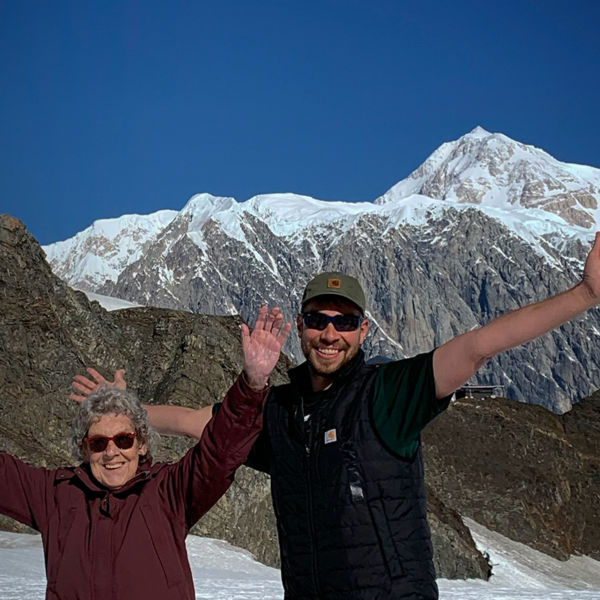 Grandma Joy and Brad Ryan pose in front of mountains