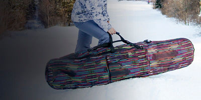 Girl snowboarder holding a case with her snowboard