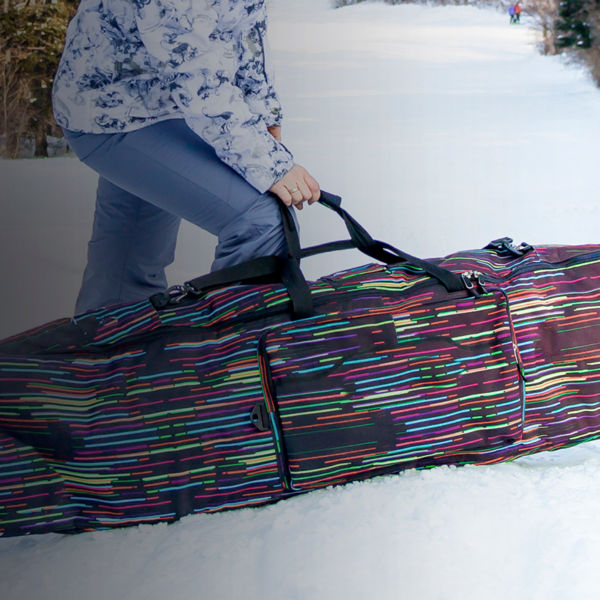 Girl snowboarder holding a case with her snowboard