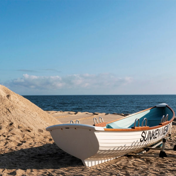 White wooden lifeguard stand and rowboat on the beach at Sunken Meadow State Park, New York