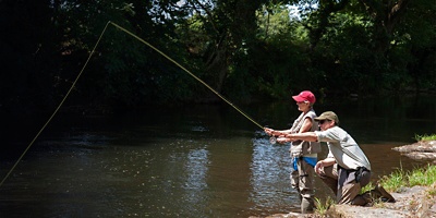 A man and a woman fishing in a river