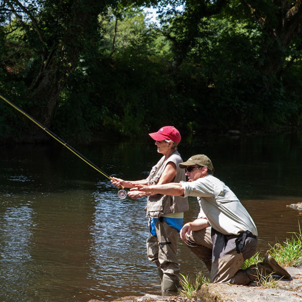 A man and a woman fishing in a river