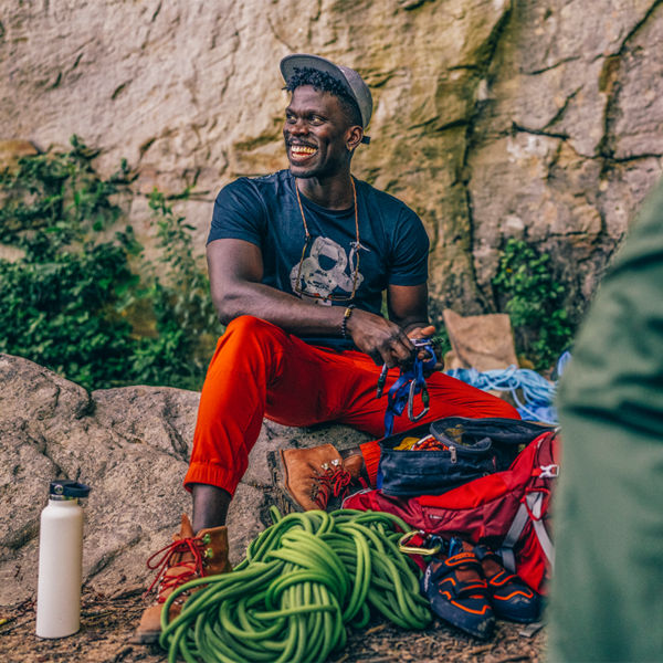 A man sits among climbing rope and gear after climbing