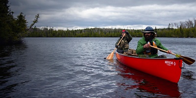 Two men paddle a red canoe on Kelly Lake  in the Boundary Waters Canoe Area Wilderness near the Baker Lake entry point in northern Minnesota 