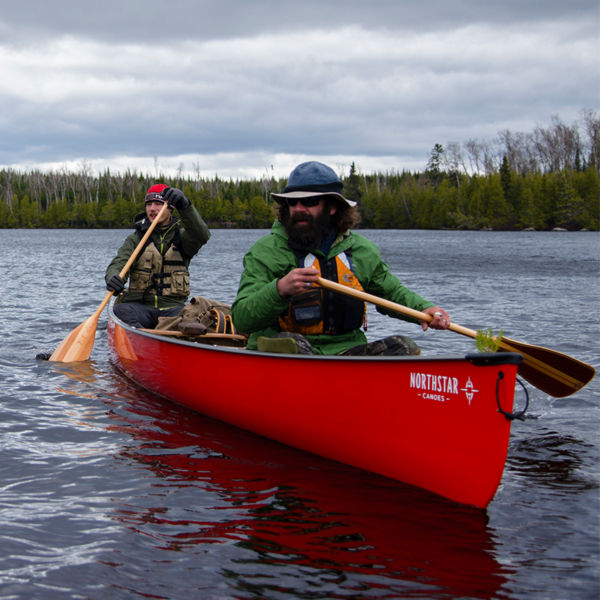 Two men paddle a red canoe on Kelly Lake  in the Boundary Waters Canoe Area Wilderness near the Baker Lake entry point in northern Minnesota 