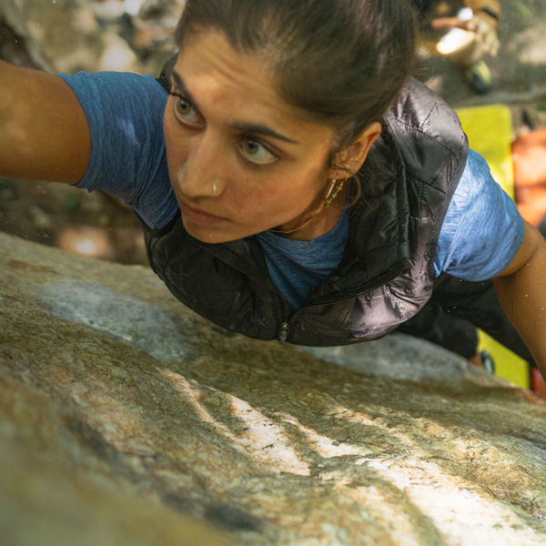 A woman grabs a hold while bouldering