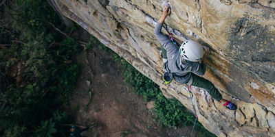 Climber on a wall wearing long sleeves and long pants