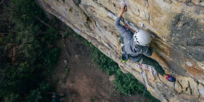 Climber on a wall wearing long sleeves and long pants