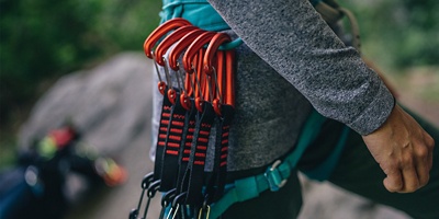 Several carabiners on the waist of a rock climber