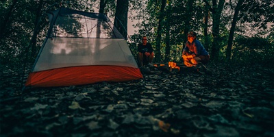 Two women sit by their tent on Sycamore Island