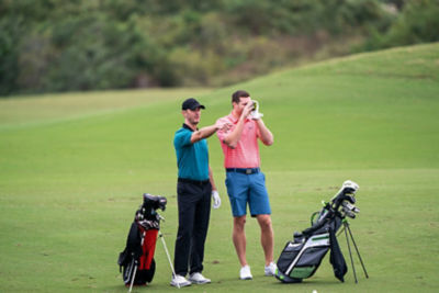Two golfers using a rangefinder