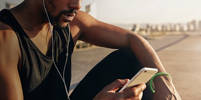 A man checks his phone outside on a break from running
