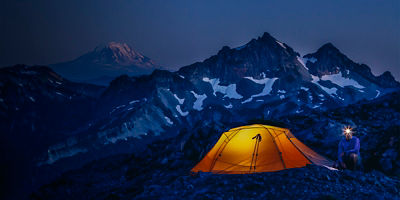 A person camps below the Tatoosh Range and Mt. Adams at dusk, Mt. Rainier National Park, Washington, United States