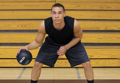 Picture of a basketball player using a weighted basketball.