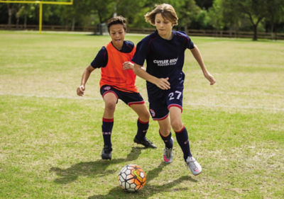 Two kids playing soccer