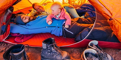 Two parents with their baby in a tent