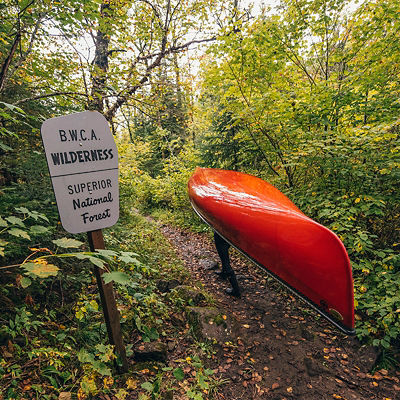 A person carrying a canoe in the boundary waters