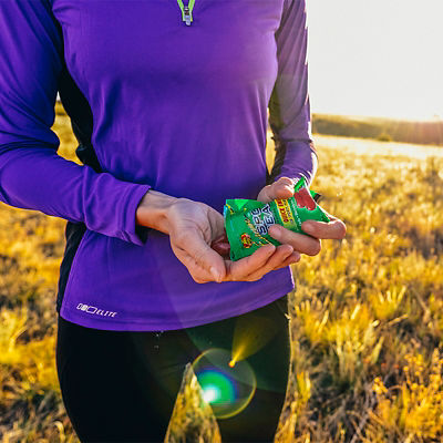 A woman eats nutrition gummies at sunrise on the trails of Green Mountain near Denver, Colorado.