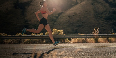 A woman running in the summer heat on a road