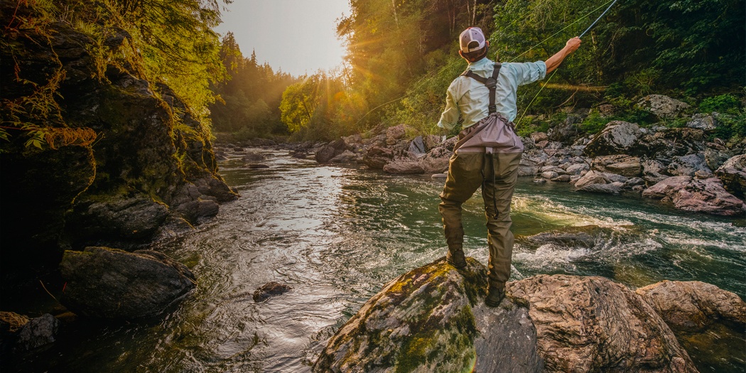 Fly Fishing Rod in Fisherman Hand. Fishing on the Mountain River