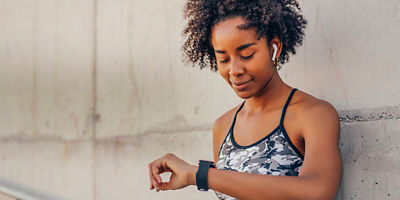 A woman looks down at her watch.