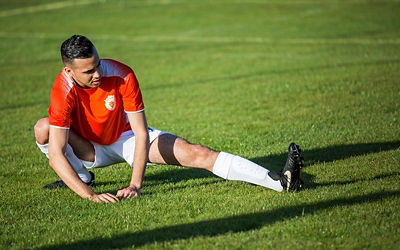 Man stretching on a soccer field