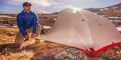 A man sets up his tent in the winter