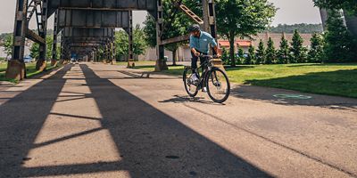 Male biker riding on a road under an underpass