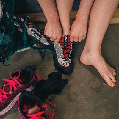 A close up shot of a climber putting on climbing shoes.