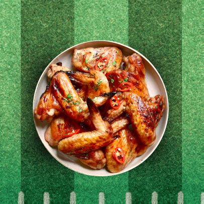 Game day chicken wings with tomatoes on a plate in a football field