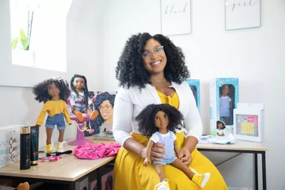 Yelitsa Jean-Charles pictured in her home office surrounded by her creation of Healthy Roots Dolls. 