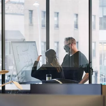 Perkins+Will employees in a New York office working with innovative technology in "Zoom rooms" to collaborate with remote workers. 