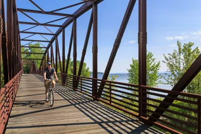 Biking man on a bridge overlooking water in Burlington, Vermont. 