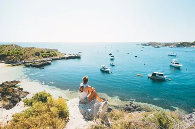 Traveling woman sitting on Longreach bay on Rottnest Island near Perth, Australia. 
